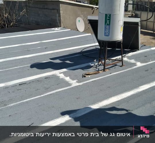 גג אטום עם שכבת איטום לבנה סביב דוד שמש